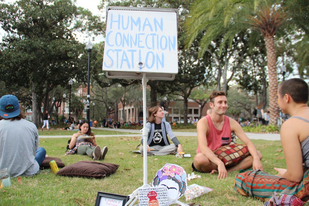 Participants started into each other’s eyes at the Human Connection Station, a public art piece displayed on Plaza of the Americas on Wednesday afternoon. The piece was displayed on the one year anniversary of the 2016 presidential election. 