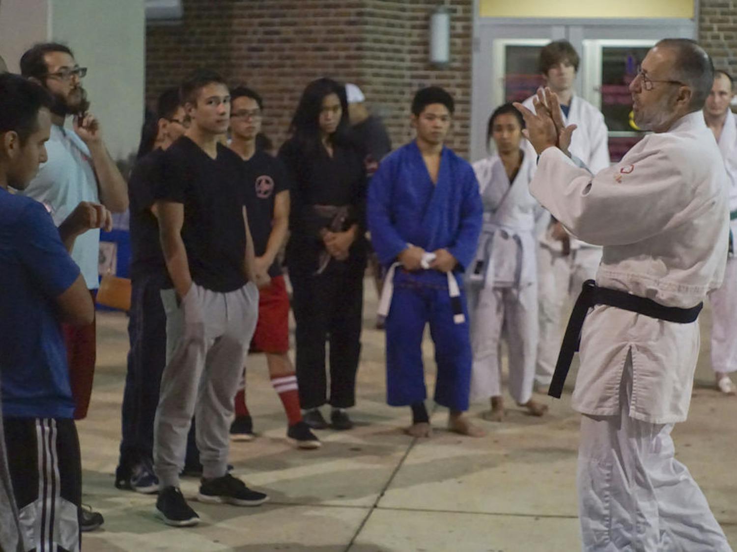 John Kammer, 66, teaches students the basics of judo Oct. 13, 2015, at Ben Hill Griffin Stadium during Asian Kaleidoscope Month’s Throwdown event. Kammer has been teaching judo for 43 years. He instructed students on basic techniques of striking, clinch-fighting and breaking grips.