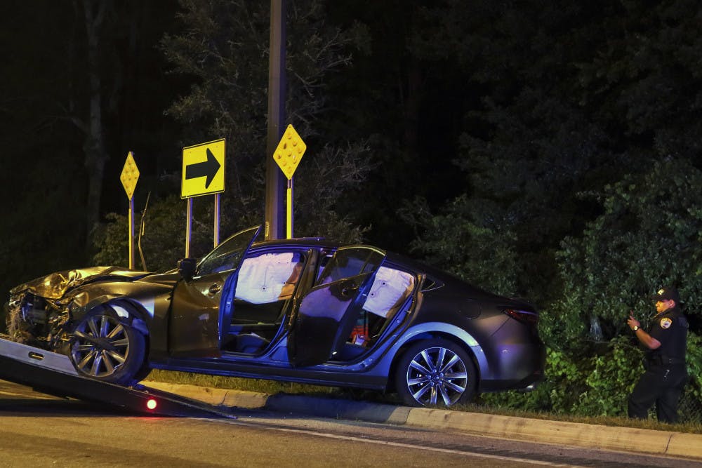 Gainesville Police Officer J. Allen inspects the crashed car Monday night. 