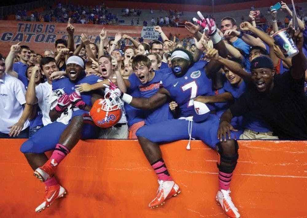 Florida football players celebrate with fans. The Swamp will see full attendance return in 2021