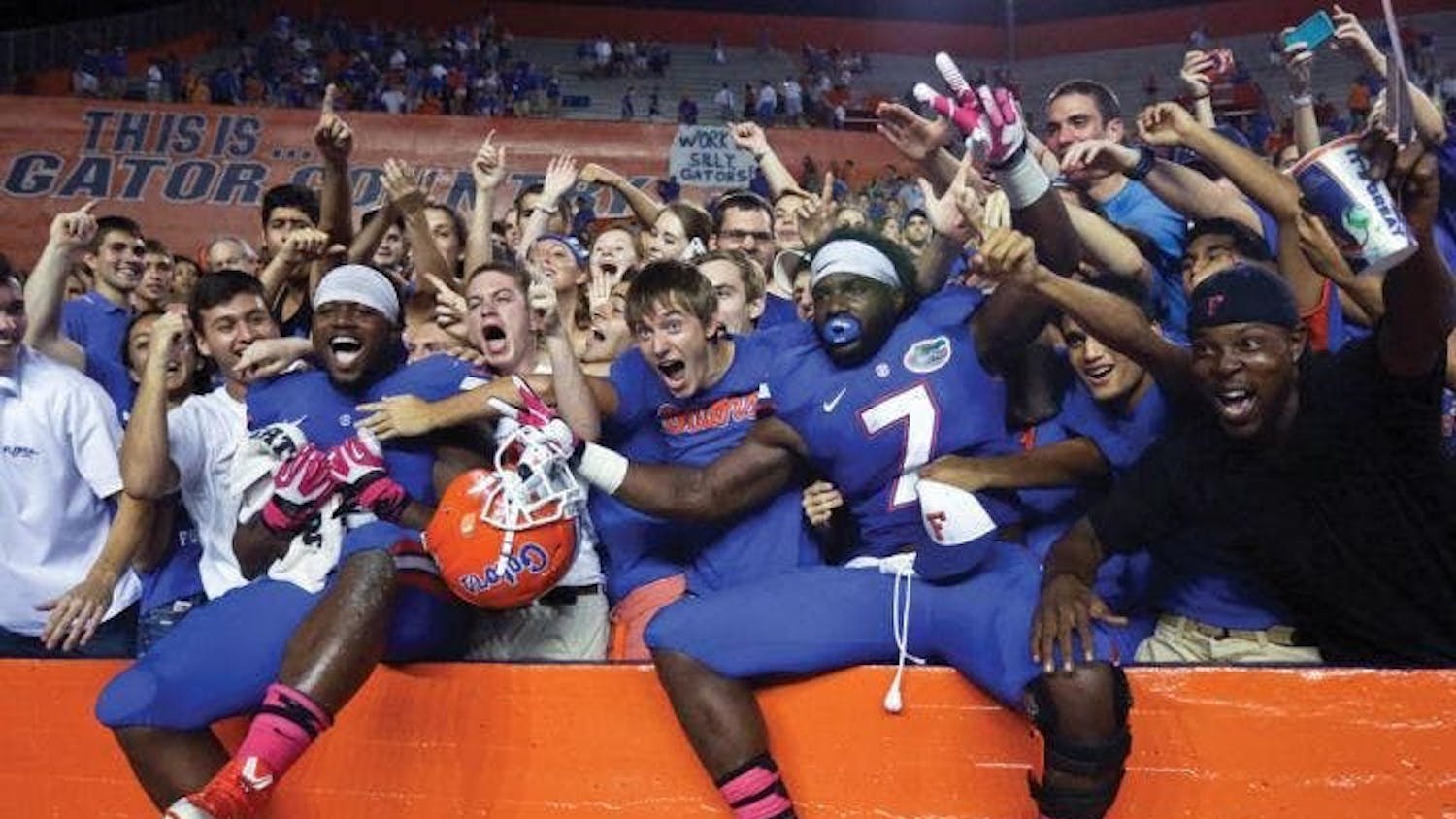 Florida football players celebrate with fans. The Swamp will see full attendance return in 2021