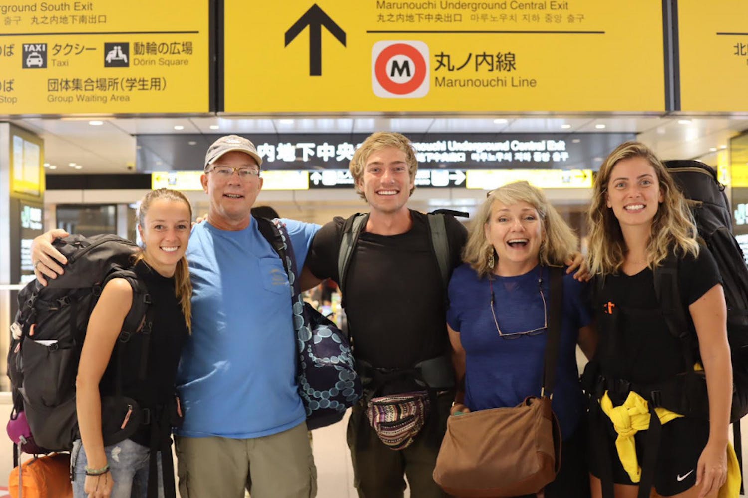Briggs (center) and the rest of Team East, Paula (left) and Renata (right), are met by his parents at a train station in Japan for the trip’s finale.