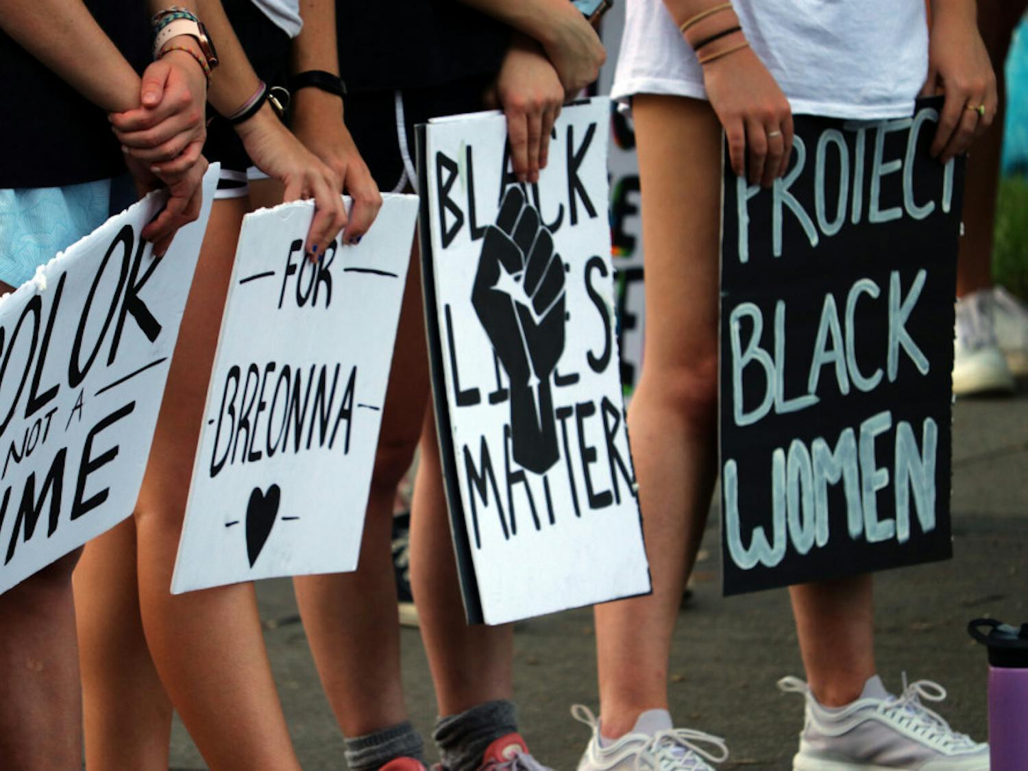 Signs stating “Color is not a crime,” “For Breonna,” “Black Lives Matter,” and “Protect black women” are seen at the protest starting at Bo Didley Plaza in Gainesville on Saturday, Sept. 26, 2020. (Asta Hemenway/Alligator Staff)