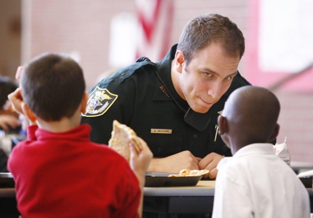 <p>Dept. Jackson of the Alachua County Sherifs Office interacts with students at lunch on Friday at the Meadowbrook Elementary cafeteria during his second day of being stationed at the school.</p>