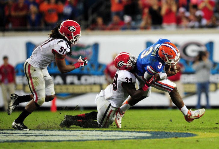 Georgia junior safety Corey Moore (39) tackles redshirt junior quarterback Tyler Murphy (3) during Florida’s 23-20 loss to the Bulldogs on Saturday at EverBank Field in Jacksonville.