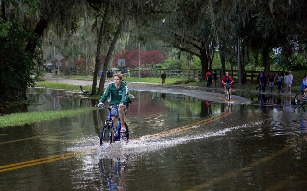 Students ride their bicycles through nearly a foot of water on the streets near Lake Alice. Lake Alice is one of the areas that flooded on campus during Hurricane Irma.