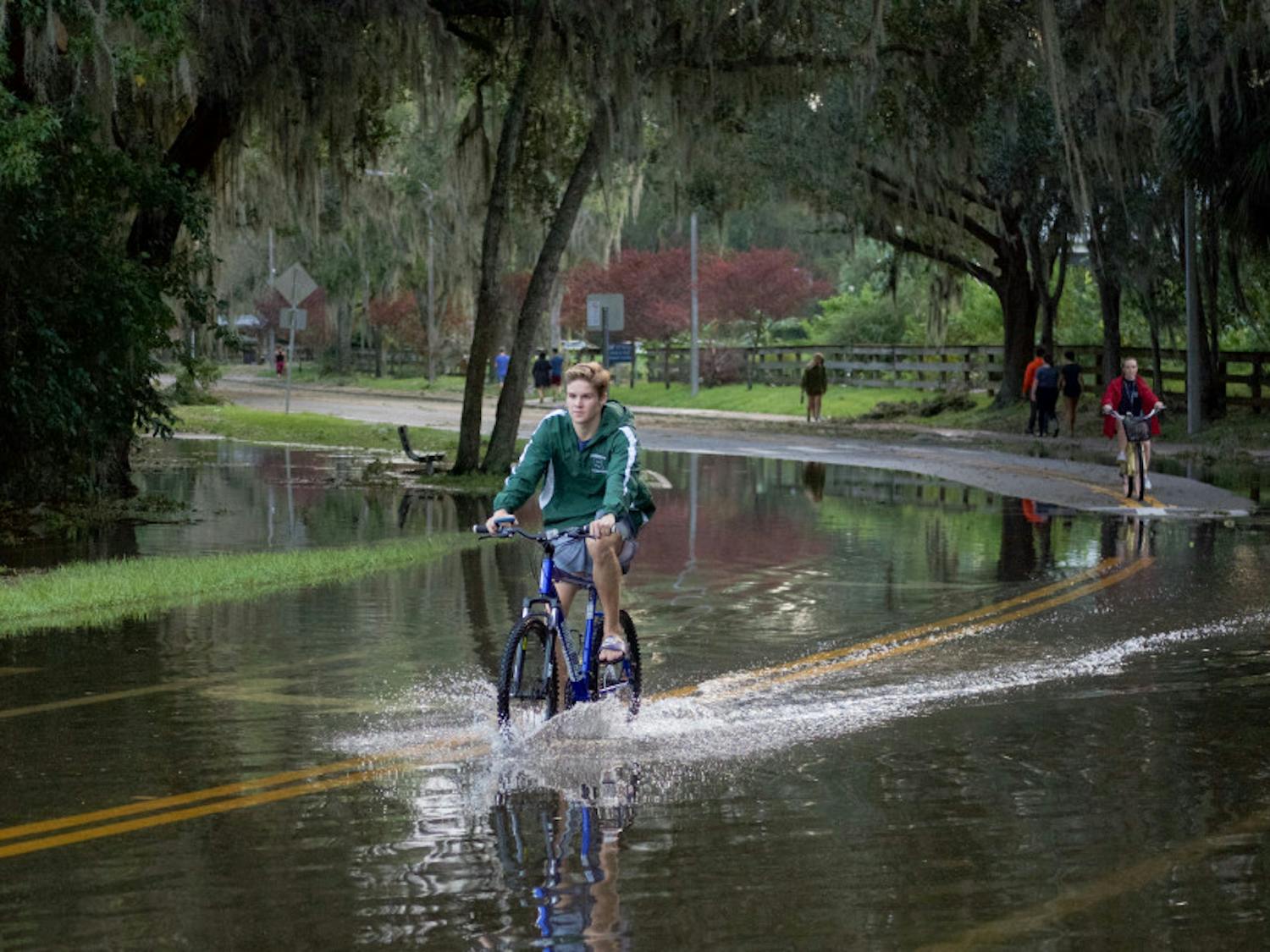 Students ride their bicycles through nearly a foot of water on the streets near Lake Alice. Lake Alice is one of the areas that flooded on campus during Hurricane Irma.