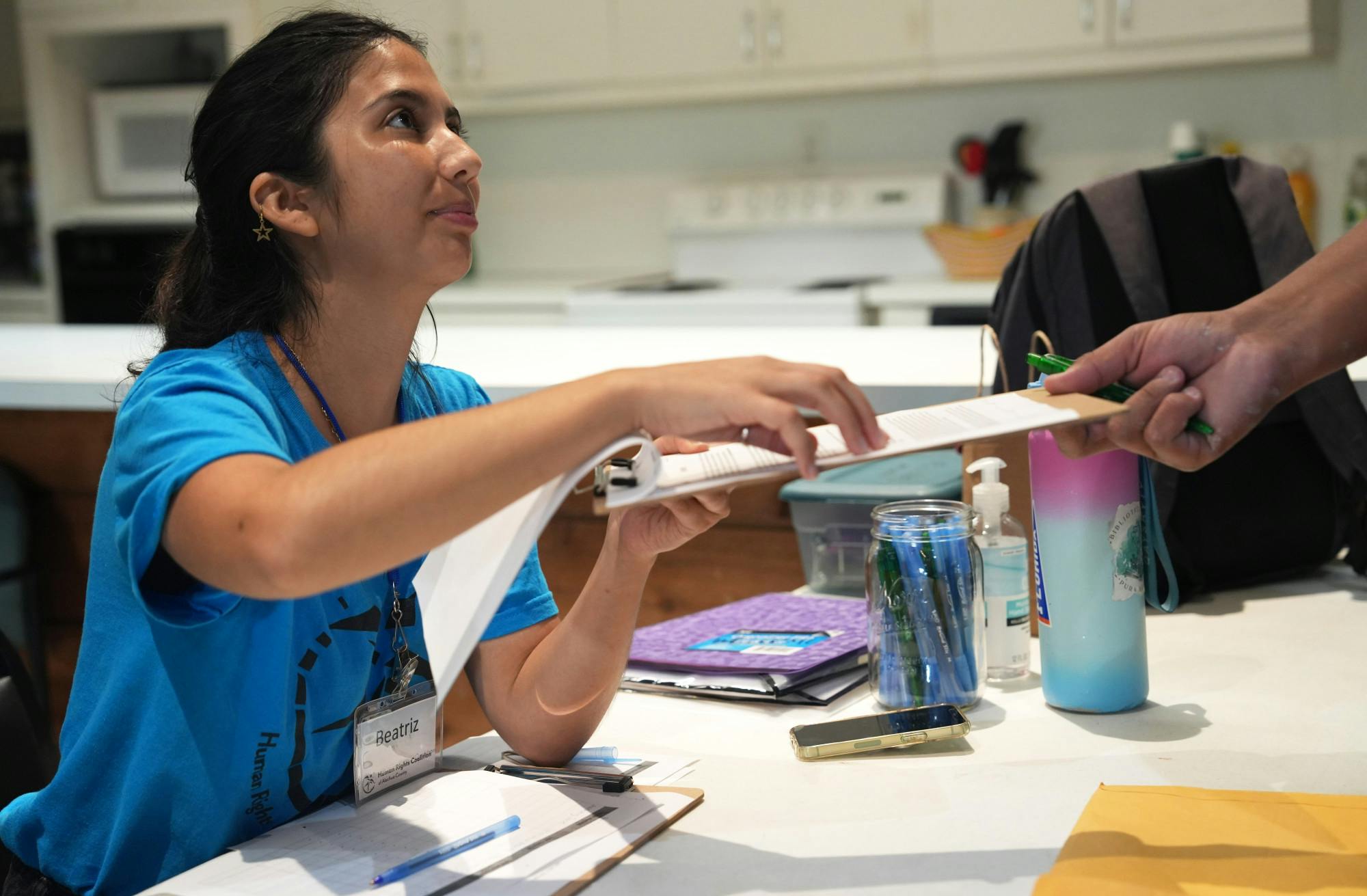 Human Rights Coalition Volunteer, Beatriz, checks in Alachua county residents arriving at Westminster Presbyterian Church to receive their community IDs on Wednesday, Sept. 6, 2023. Beatriz, voluntaria de la Coalición de Derechos Humanos, registra a los residentes del condado de Alachua que llegan a la Iglesia Presbiteriana de Westminster para recibir sus identificaciones comunitarias el miércoles, 6 de Septiembre de 2023.