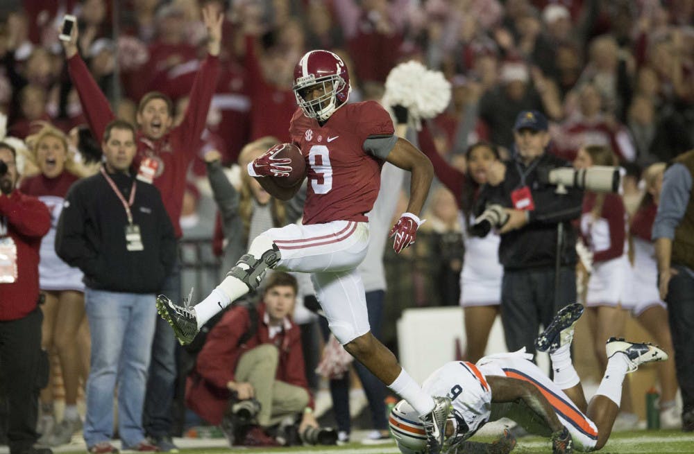 Alabama wide receiver Amari Cooper (9) scores a 75-yard touchdown reception as Auburn defensive back Jonathon Mincy (6) attempts to tackle him during Alabama's 55-44 win against Auburn on Saturday.