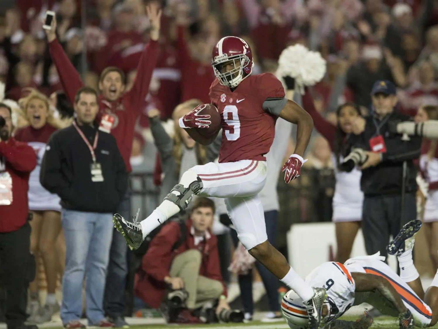 Alabama wide receiver Amari Cooper (9) scores a 75-yard touchdown reception as Auburn defensive back Jonathon Mincy (6) attempts to tackle him during Alabama's 55-44 win against Auburn on Saturday.