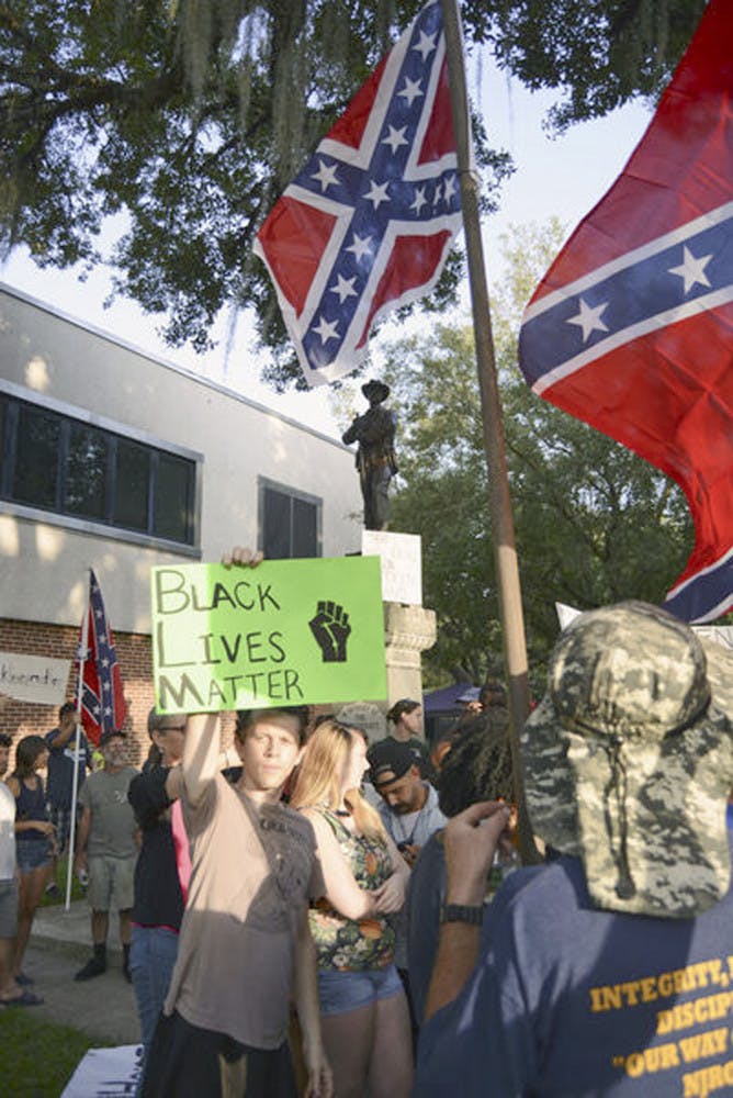 A protestor holds up a sign reading “Black Lives Matter,” in front of the statue memorializing fallen Confederate soldiers from the Civil War on July 9, 2015. Today’s Alachua County Commissioners meeting may conclude the debate over whether to remove the statue.