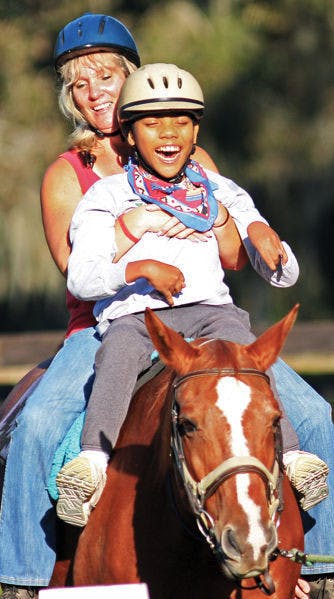 Daniel Ratovoson rides a horse on Oct. 16 at Stirrups ‘n’ Strides, a therapeutic horseback riding center in Citra, Fla.