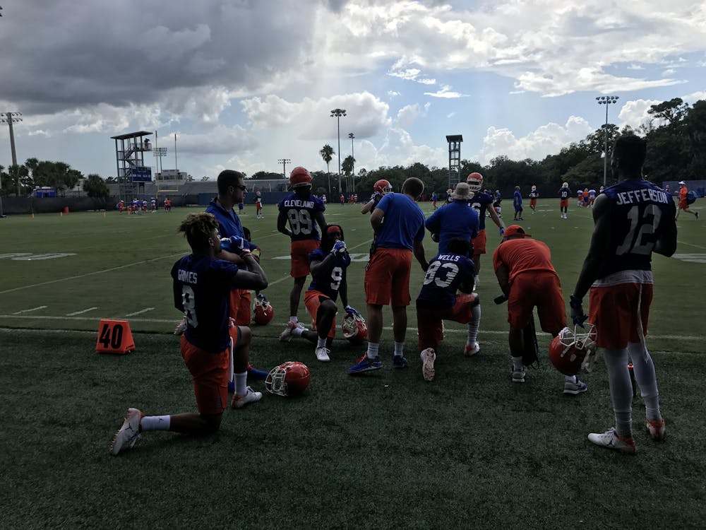 <p>A unit of Florida wide receivers, including transfers Van Jefferson (12) and Trevon Grimes (8), rests during Day 1 of fall camp after catching passes from the quarterbacks. </p>
