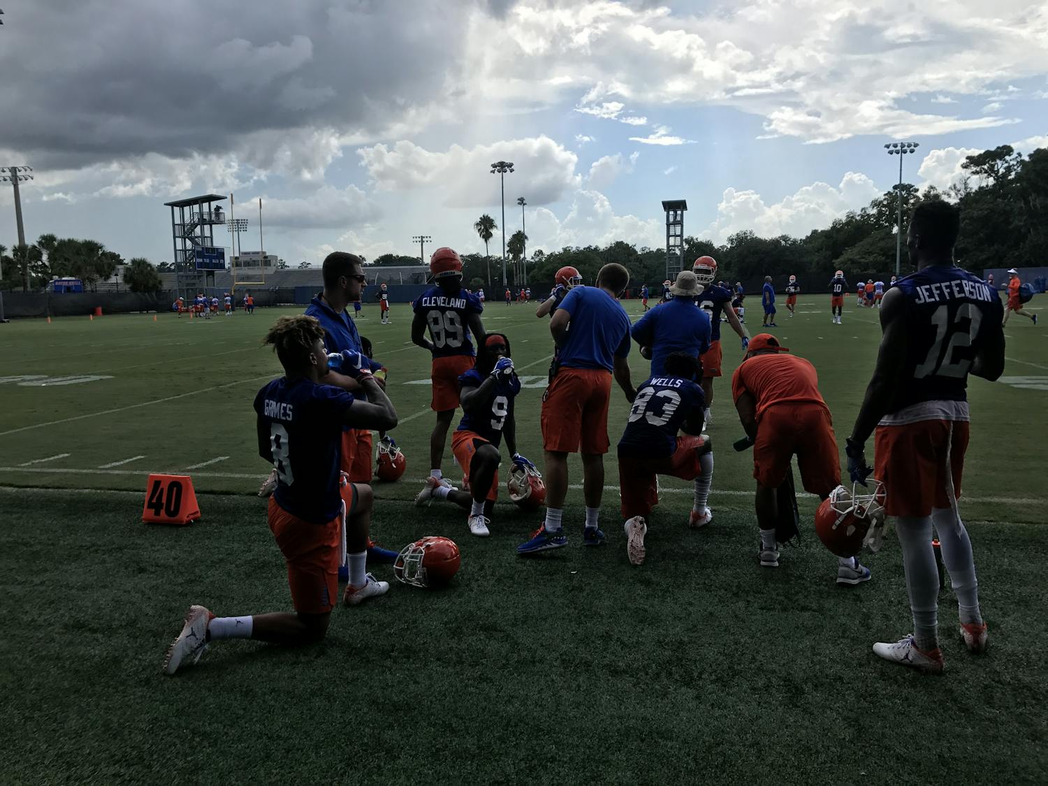 A unit of Florida wide receivers, including transfers Van Jefferson (12) and Trevon Grimes (8), rests during Day 1 of fall camp after catching passes from the quarterbacks.