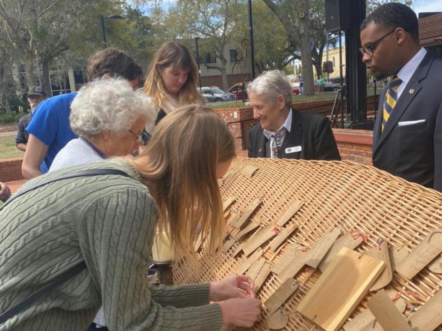 Residents pictured are gathered around the lid of the coffin of Rose ‘Granny’ McDonald-Loston. They wrote notes to her and tied them onto the lid. She was buried after the service at Prairie Creek Conservation Cemetery, located at 7204 County Road 234.