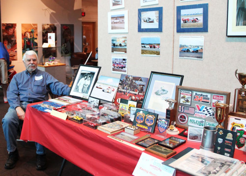 <p class="p1"><span class="s1">Louis Galanos, a 68-year-old Gainesville resident, displays his collection of racing memorabilia on Saturday at the 35th annual Collectors Day at the Florida Museum of Natural History.</span></p>