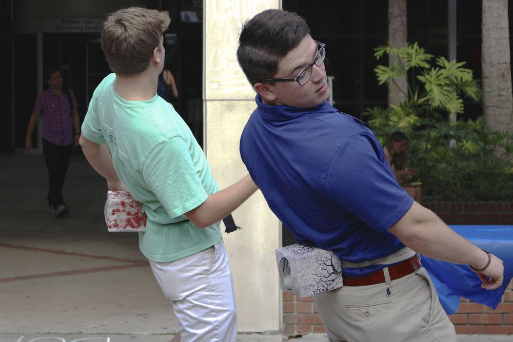 <p>Brady Bernstein, an 18-year-old UF criminology and law freshman, plays a game called Junk in the Trunk during the Field, Fork, and Fashion event on the Plaza of the Americas on Dec. 1, 2015. The Freshman Leadership Council member, part of the organization's Special Events Committee, shook a tissue box filled with ping pong balls strapped to his back.</p>
