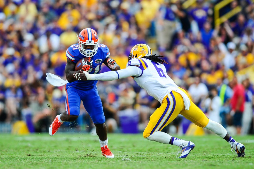 Kelvin Taylor (left) lunges away from Tigers senior safety Craig Loston during Florida’s 17-6 loss to LSU on Saturday at Tiger Stadium in Baton Rouge, La. The freshman tailback carried the ball 10 times for 52 yards.