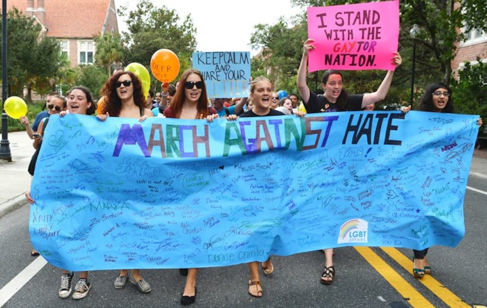 <p>Students march down Buckman drive during the March Against Hate on Thrusday afternoon. Several UF student organizations joined together to hold the demonstration.</p>