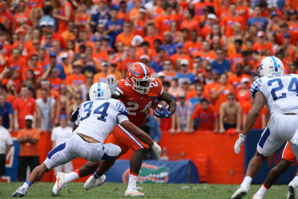 <p>Gators running back Mark Thompson stiff arms a Kentucky Wildcats defender during Florida's 45-7 win against Kentucky on Sept. 10, 2016.</p>