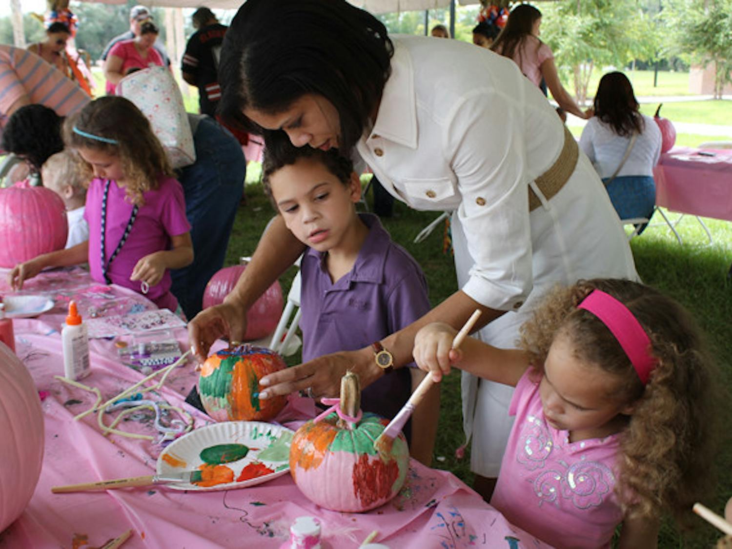 Holly Knapick paints pumpkins Saturday at the Cancer Genetics Research Complex with her son Jack, 5, and daughter Angie, 3. She lost two aunts to the disease and thought the party would be fun.
