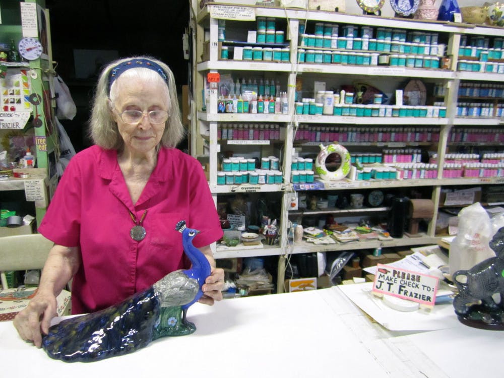 <p>Juanita Frazier, 85, shows a ceramic peacock she repaired and painted herself. She has owned Frazier Ceramic Shop, 8601 SW Williston Road, since 1971 after moving back to Alachua County.</p><div> </div>