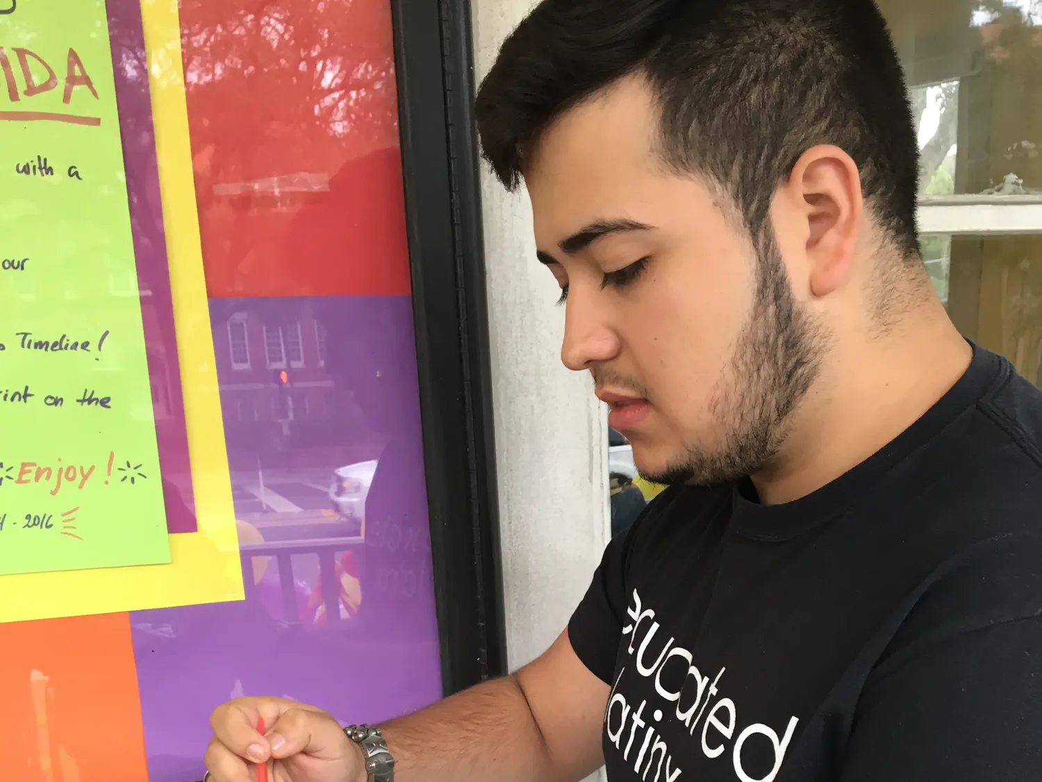 Gabriel Costa, a 20-year-old UF music performance and nutrition sophomore, paints the flag of Brazil onto his hand to decorate the front of La Casita. Students left their handprints on the building as a final farewell.