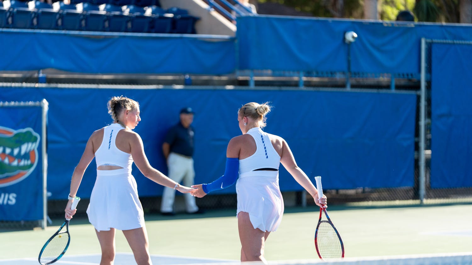 Florida women's tennis pairing of Alicia Dudeney and Malwina Rowinska high-five each other after a point in the team's match against Mississippi State on Friday, March 29, 2024. 