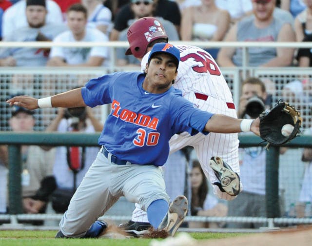 South Carolina's Brady Thomas (36) is safe at first base against Florida first baseman Vickash Ramjit (30) on an RBI-single in the third inning of Game 2 of the NCAA baseball College World Series best-of-three finals, in Omaha, Neb., Tuesday, June 28, 2011. (AP Photo/Eric Francis)