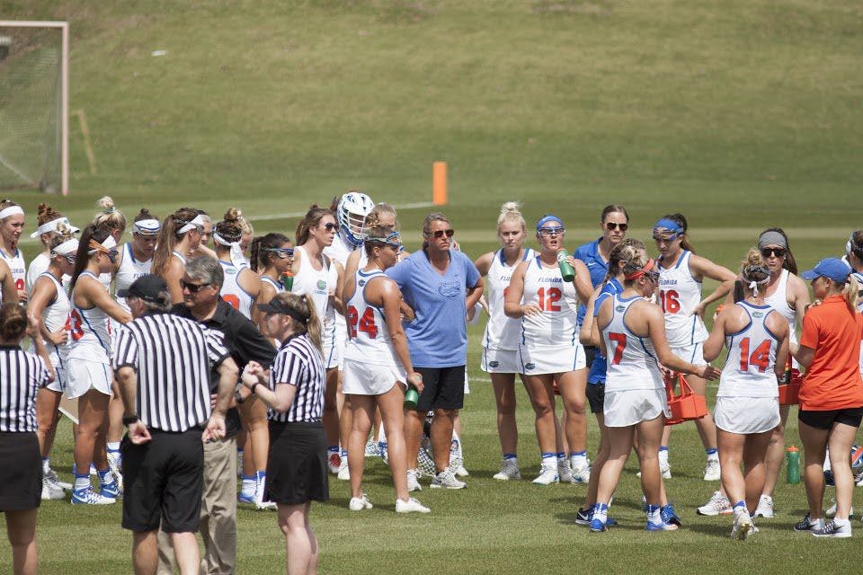 UF lacrosse head coach Amanda O'Leary stands in the center of her players during Florida's 15-8 win against Denver on March 25, 2017, at Donald R. Dizney Stadium.