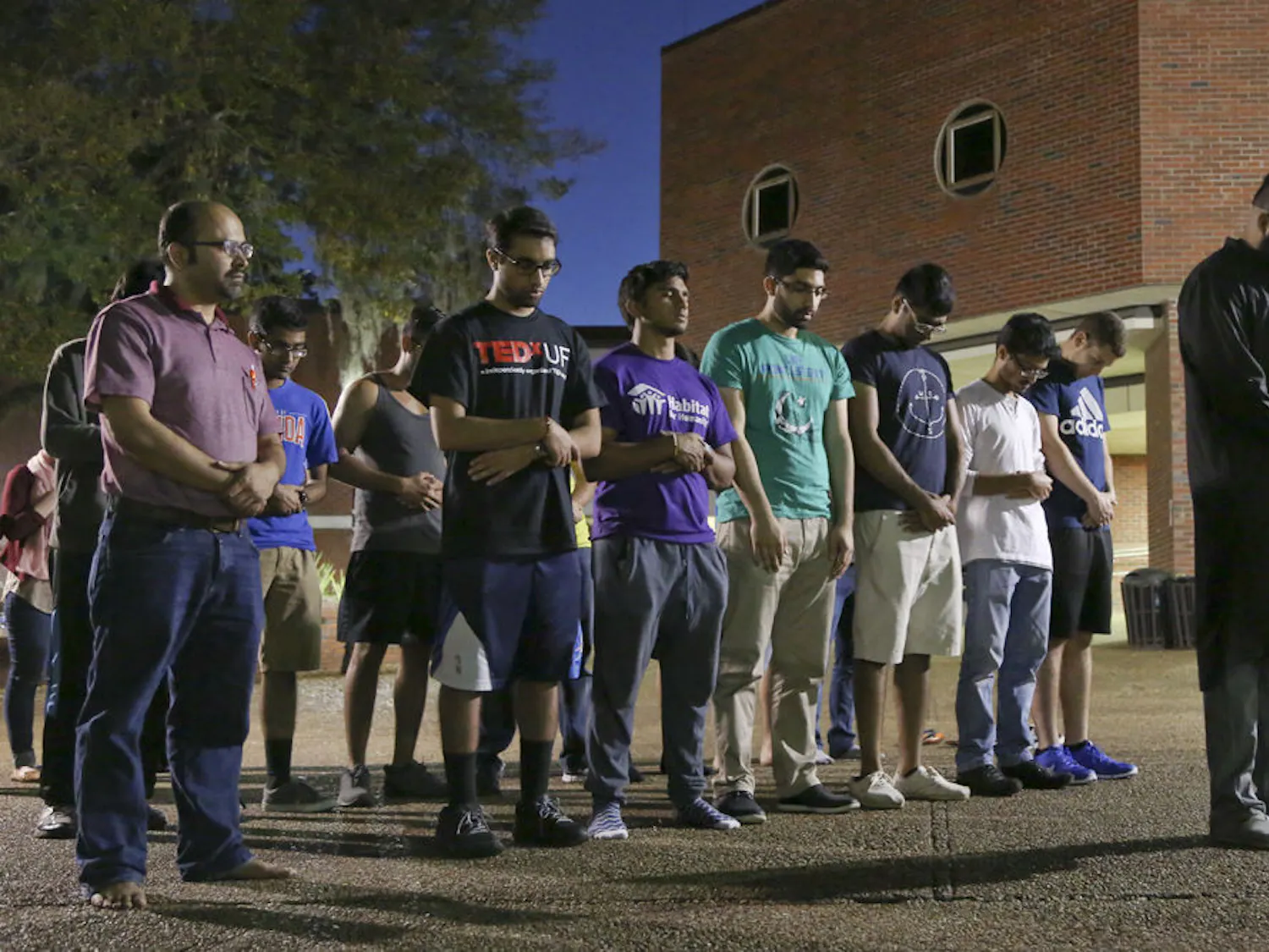 Zubin Kapadia, a 21 year-old UF history senior, leads a group of Muslim UF community members in prayer honoring those killed during the terrorist attack in Pakistan on March 28. About 40 people attended the Monday night candlelight vigil on Turlington Plaza.