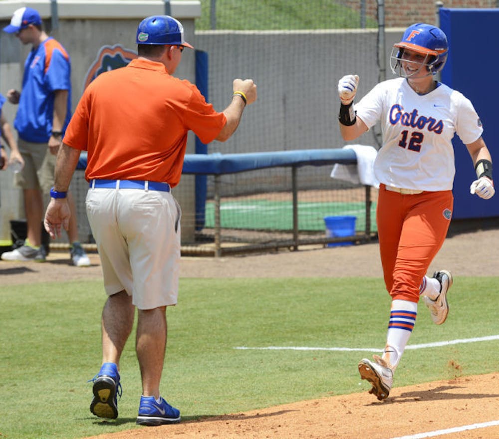 <p>Taylore Fuller fist-bumps coach Tim Walton as she rounds third base after hitting a home run on May 18 against USF.</p>