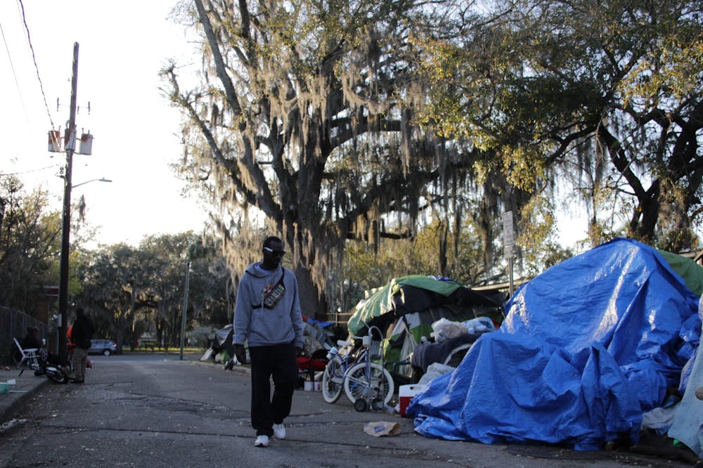 A man walks through the homeless encampment Southeast Fourth Place on Sunday, Feb. 25, 2024.