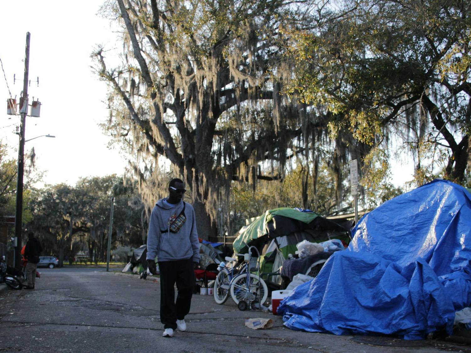 A man walks through the homeless encampment Southeast Fourth Place on Sunday, Feb. 25, 2024.
