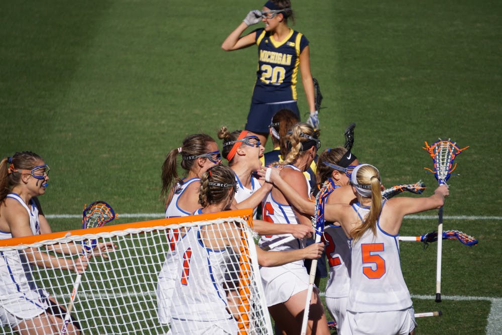 The Florida lacrosse team celebrates Sammi Burgess' game-winning goal during UF's 12-11 win over Michigan on Saturday at Donald R. Dizney Stadium. 