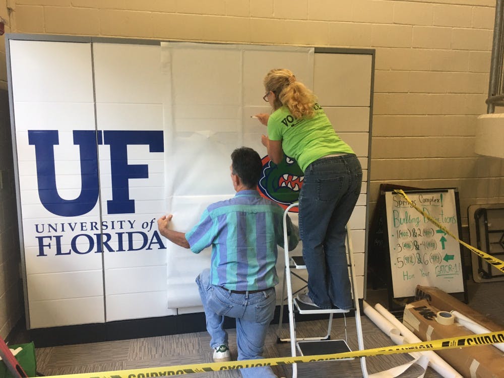 Jim and Starlyn Fikkert of Great Bay Signs install Gator decals to the mailing systems in Springs Complex. There is not an official operational start date for the lockers.  