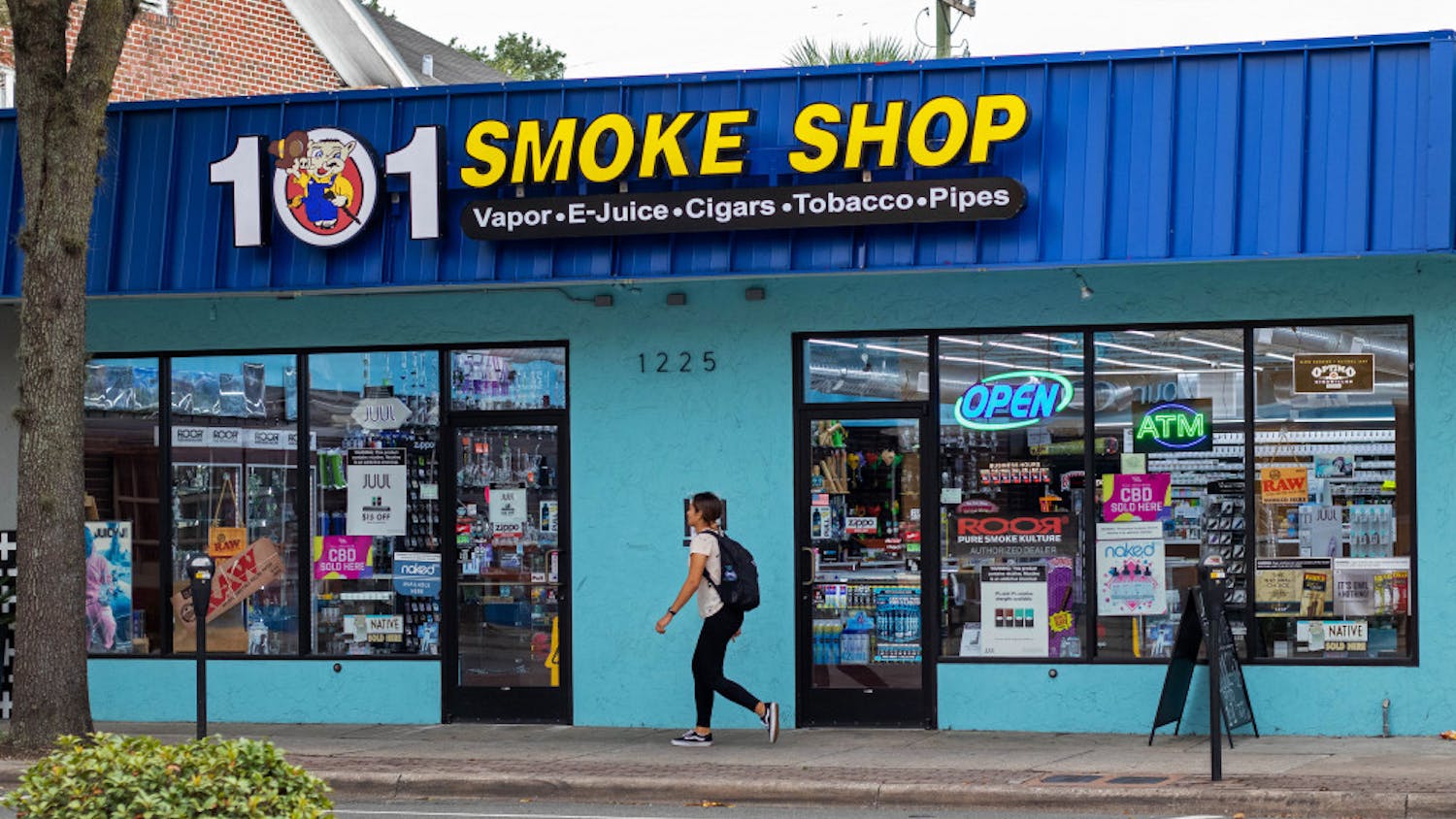 A woman walks by 101 Smoke Shop on SW Archer Road.