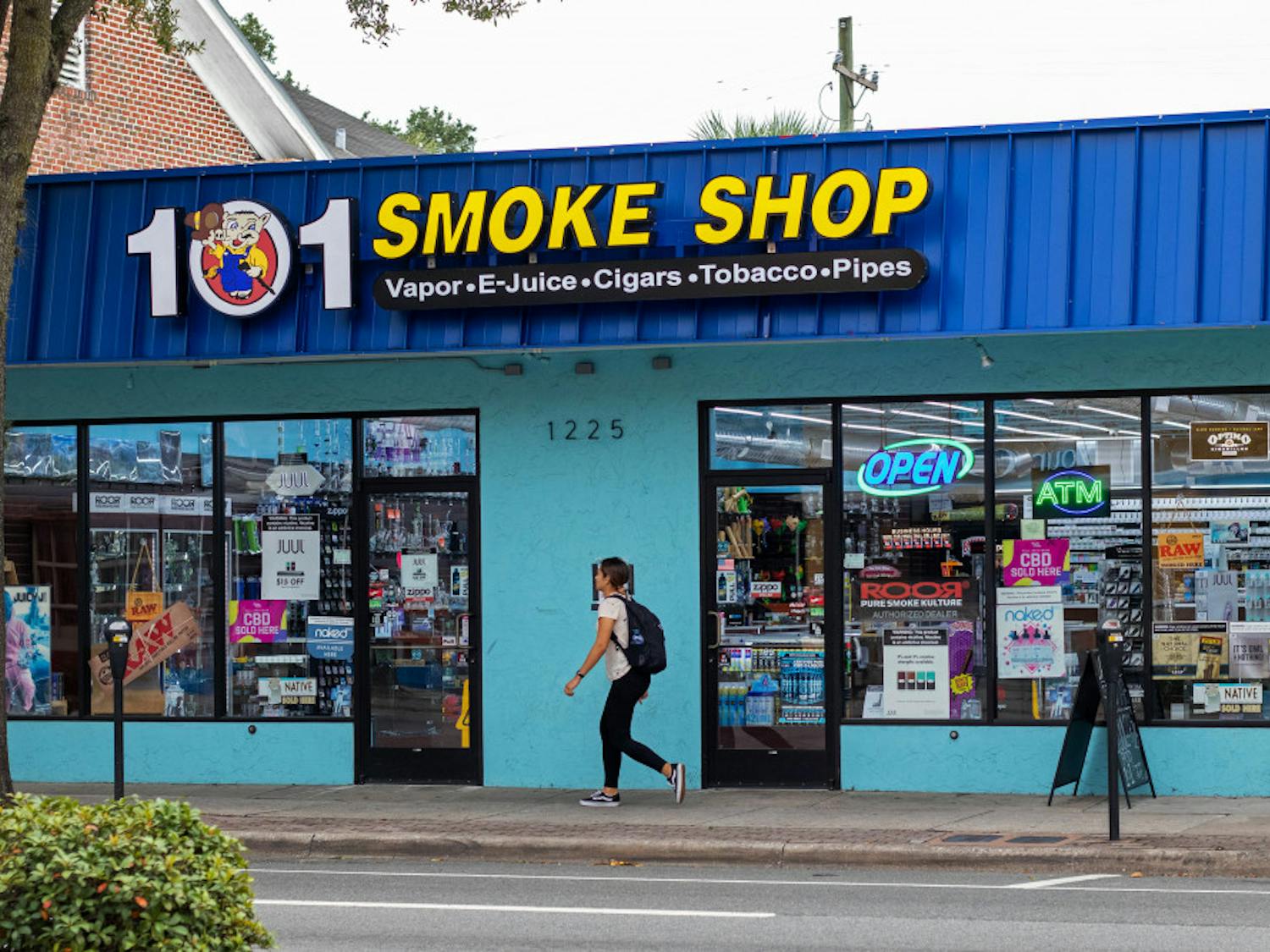 A woman walks by 101 Smoke Shop on SW Archer Road.
