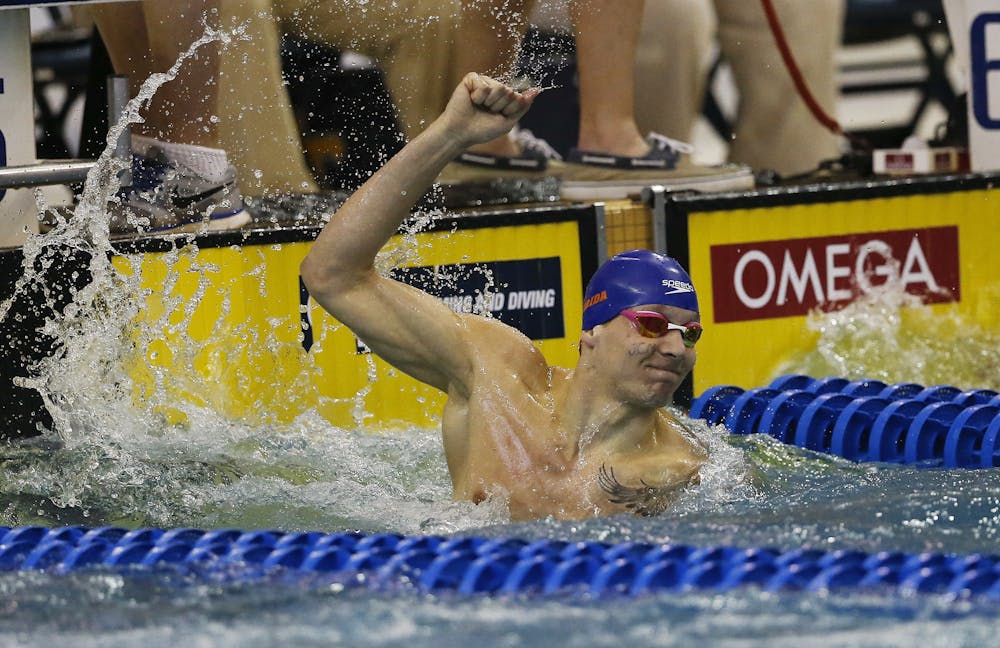 <p>Florida's Caeleb Dressel reacts after winning the 100-yard freestyle at the NCAA men's swimming and diving championships Saturday, March 26, 2016, in Atlanta. The initials on his face are in honor of a former teacher. (AP Photo/John Bazemore)</p>