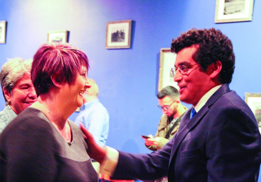 From left: Lisa Marshall congratulates David Arreola, 26, on his District 3 win Tuesday night at a results watch party at Blue Gills Quality Foods. 