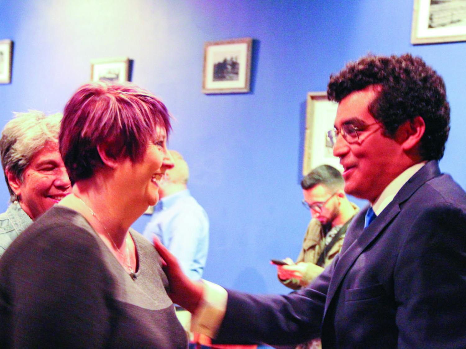 From left: Lisa Marshall congratulates David Arreola, 26, on his District 3 win Tuesday night at a results watch party at Blue Gills Quality Foods.