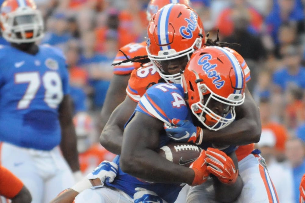 <p>Safety Marcell Harris (26) tackles running back Mark Thompson during the Orange &amp; Blue Debut on April 8, 2016, at Ben Hill Griffin Stadium.</p>