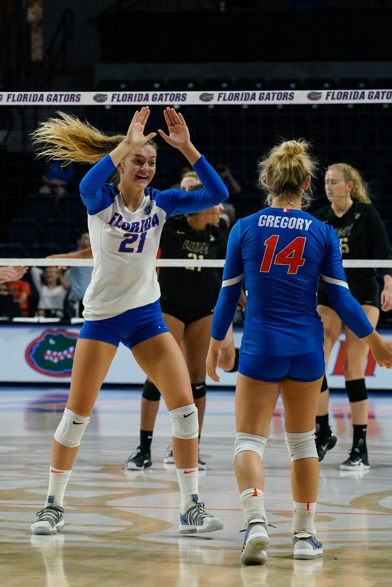 Freshman setter Marlie Monserez (21) celebrates with libero Allie Gregory after a Florida point on Sept. 15 against Army. 