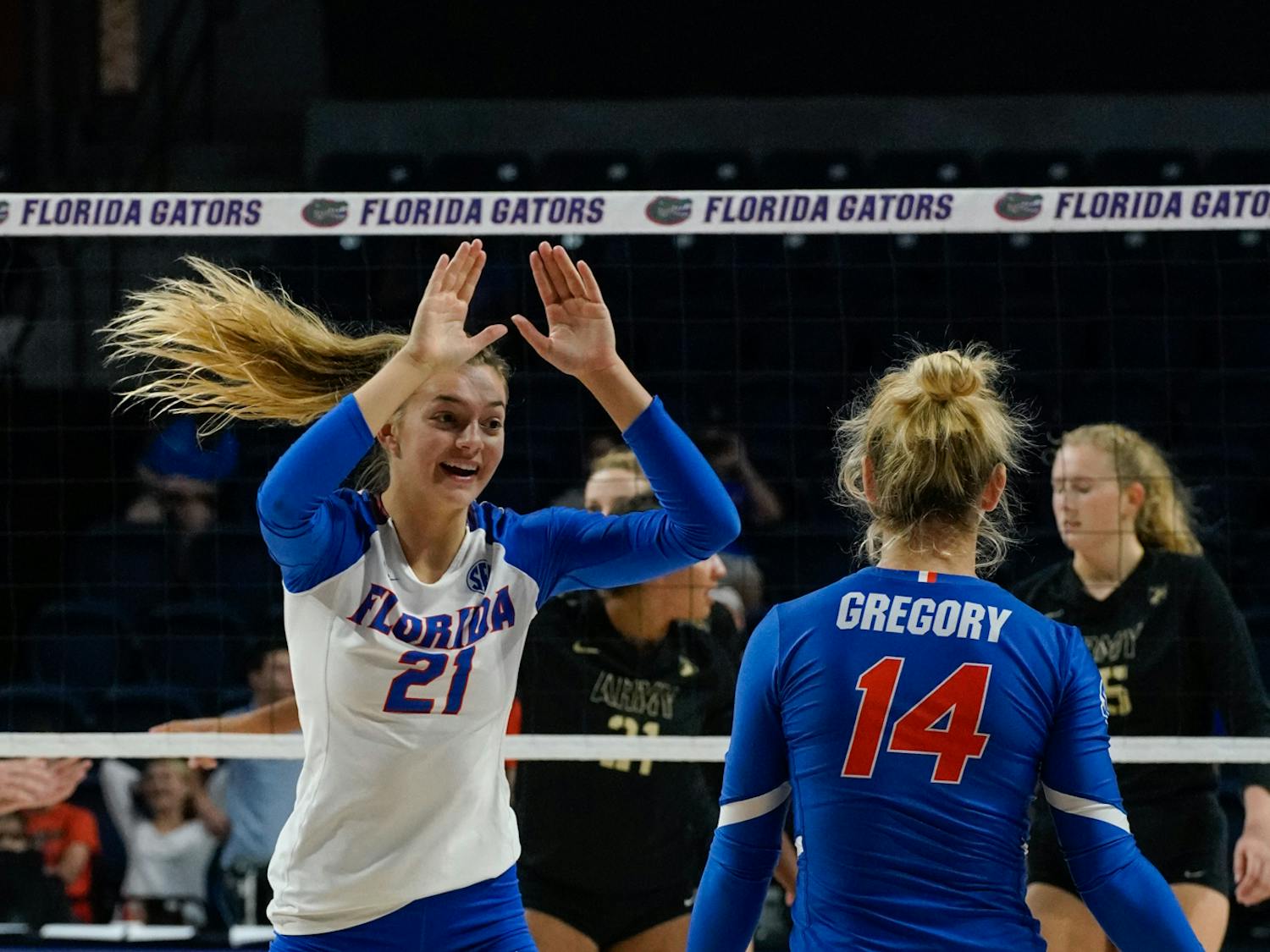 Freshman setter Marlie Monserez (21) celebrates with libero Allie Gregory after a Florida point on Sept. 15 against Army. 