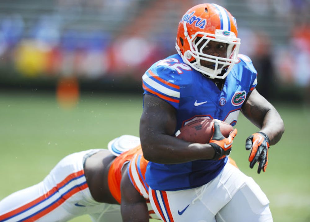 <p>Adam Lane (22) breaks a tackle during Florida’s Orange and Blue Debut on Saturday in Ben Hill Griffin Stadium. Lane was UF’s leading rusher during the game.</p>