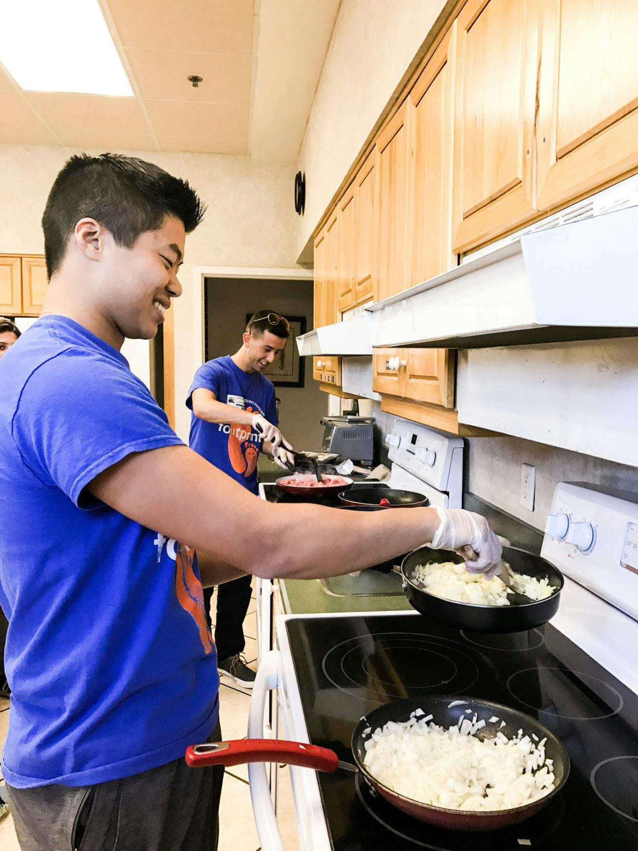 From left: Zachary Sandoval, a UF biology and psychology sophomore, cooks onions while Grant Filowitz, a UF graduate student, browns beef on a nearby stove at the Ronald McDonald House of Gainesville. The two Footprints Buddy and Support Program volunteers made sloppy joes for the families of the patients in Unit 42.