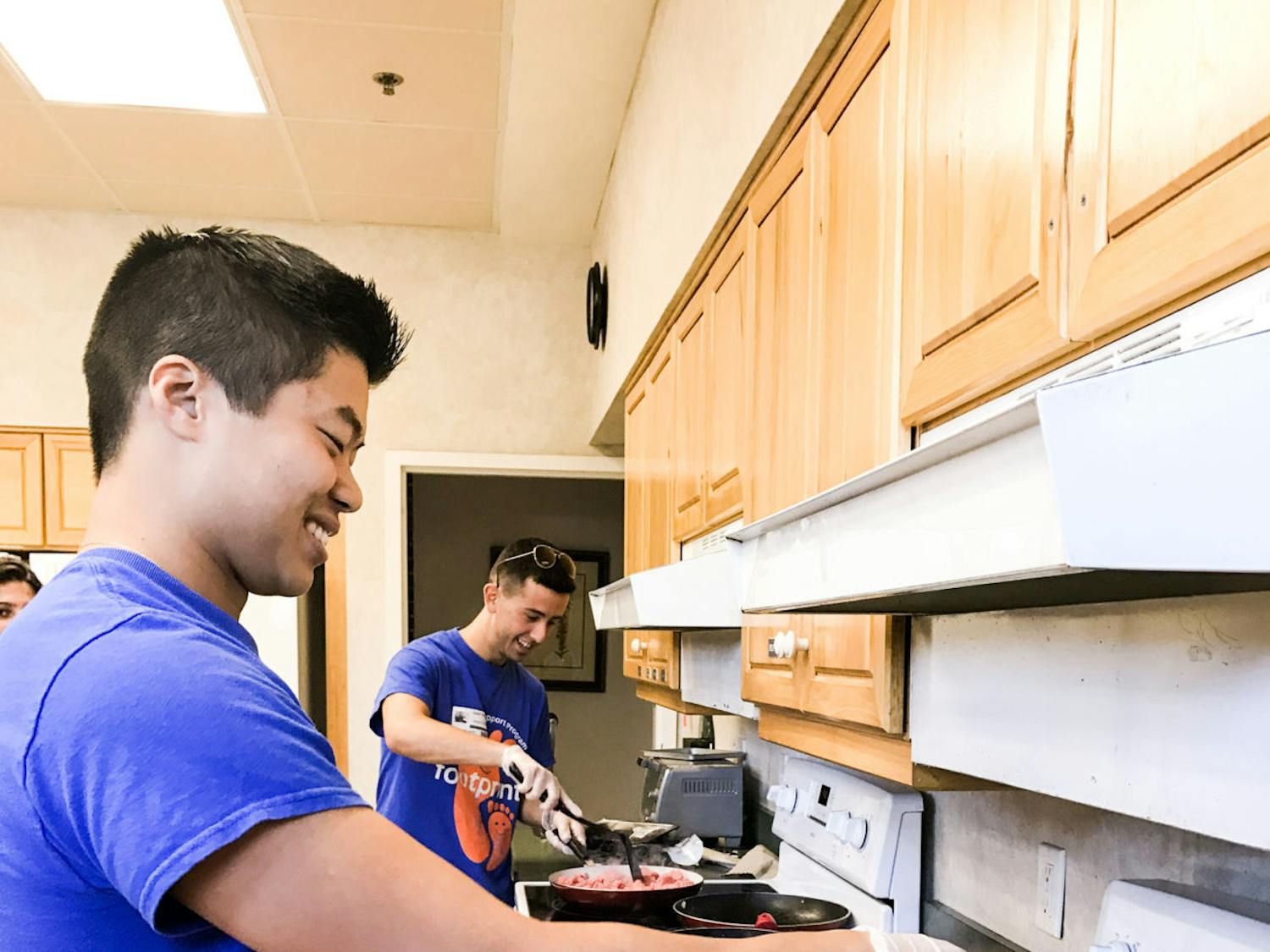 From left: Zachary Sandoval, a UF biology and psychology sophomore, cooks onions while Grant Filowitz, a UF graduate student, browns beef on a nearby stove at the Ronald McDonald House of Gainesville. The two Footprints Buddy and Support Program volunteers made sloppy joes for the families of the patients in Unit 42.
