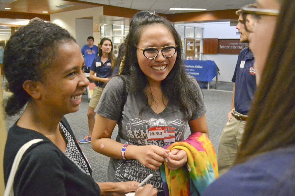 <p>Maria A. B. Gama (left), a 22-year-old biochemistry senior, and Nurul Azma Ahmad Tarmizi, a 21-year-old food science and human nutrition junior, share a laugh at the Gatornational Language and Culture Fair at the Hub on Oct. 8, 2015. The UF Campus Diplomats hosted the event to connect international students on campus. Tarmizi said it was important to represent her country, Indonesia.</p>