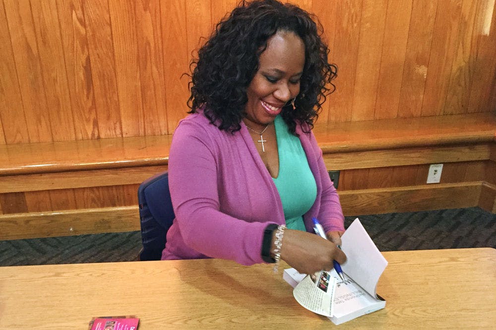 <p>ReShonda Billingsley signs a book for a fan in the Alachua County Library Headquarters on Saturday afternoon. Billingsley was at the library as a speaker for The Opinionated Ladies Book Club of Gainesville’s 7th anniversary.</p>