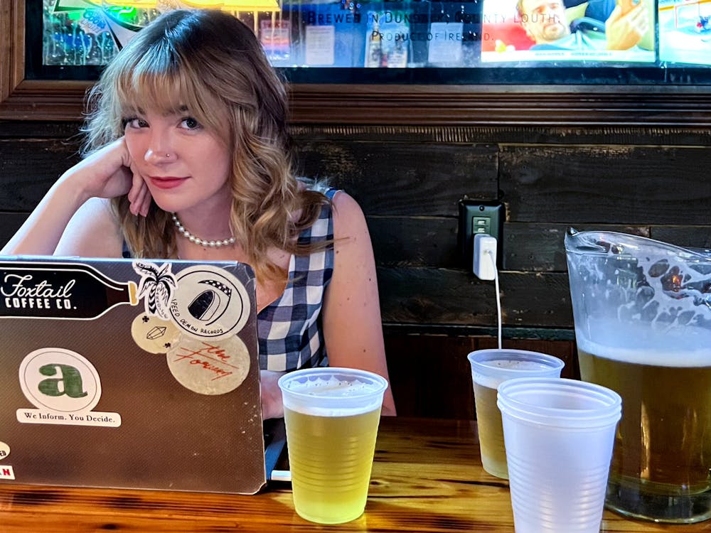 <p>Julia Coin, a 21-year-old former Editor-in-Chief of The Independent Florida Alligator, preps for her final semester on staff at a Midtown Bar earlier this summer. </p>